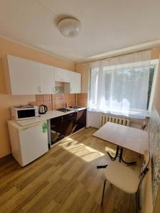 a small kitchen with a table and a microwave at Сomfort24 Апартаменти на проспекті Гагаріна Мечнікова Apartment on Gagarina in Dnipro