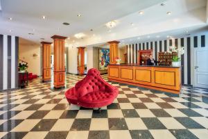 a red chair in the lobby of a salon at Weinromantikhotel Richtershof in Mülheim an der Mosel