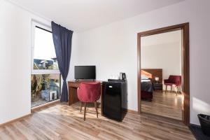 a room with a desk and a bed and a mirror at Penzión SESSLER *** in Trnava