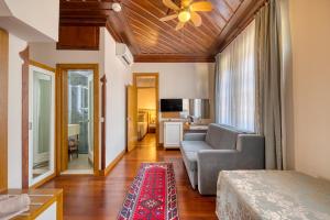 فندق دوغان في أنطاليا: غرفة معيشة مع أريكة وكرسي في غرفة