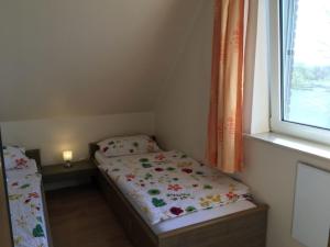a small bedroom with two beds and a window at zum Wels in Wester-Ohrstedt