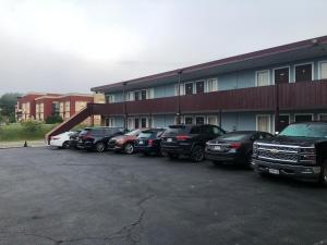 eine Reihe von Autos, die vor einem Gebäude geparkt sind in der Unterkunft Red Carpet Inn - Blacksburg in Blacksburg