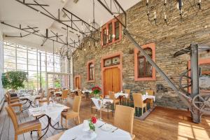 a restaurant with tables and chairs and a brick wall at Weinromantikhotel Richtershof in Mülheim an der Mosel