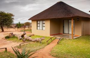 Cette petite maison est dotée d'un toit de chaume. dans l'établissement Bongan Safari Lodge, à Mbabat