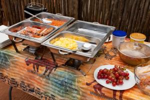a table with two trays of food and a plate of grapes at Bongan Safari Lodge in Mbabat