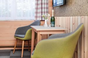 einen Tisch mit 2 Stühlen und eine Flasche Wein in der Unterkunft Hotel & Restaurant Waldblick in Pulsnitz