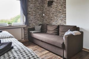 - un canapé dans le salon avec un mur en briques dans l'établissement Fewo Helm, à Elsoft