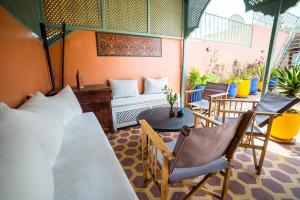 een kamer met een patio met stoelen en een bank bij Riad Inaka in Marrakesh
