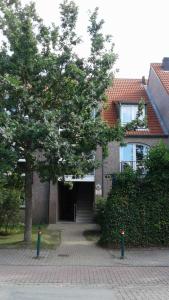 un edificio con un albero di fronte di Fewo 514 in Tossens a Tossens