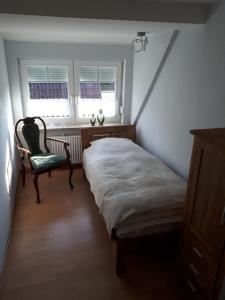 BurgstaakenにあるFewo Pahlke 1291のベッドルーム1室(ベッド1台、椅子1脚、窓2つ付)