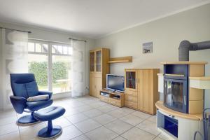 sala de estar con silla azul y TV en Gotland 2 en Zingst