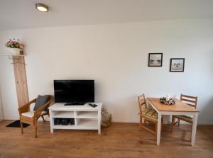 ein Wohnzimmer mit einem TV und einem Tisch in der Unterkunft Ferienwohnungen Legienstraße in Hamburg