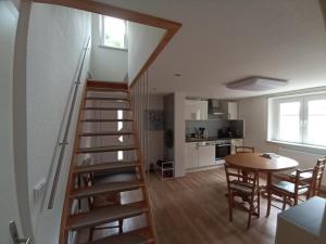 eine Treppe in einem Zimmer mit einem Tisch und einer Küche in der Unterkunft Ferienwohnung zum Hirschgrund in Schöna