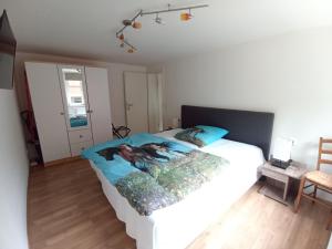 ein Schlafzimmer mit einem weißen Bett mit einem Gemälde darauf in der Unterkunft Ferienwohnung zum Hirschgrund in Schöna