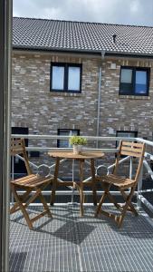 einen Holztisch und zwei Stühle auf einer Terrasse in der Unterkunft Alte Käserei Ferienwohnungen in Flensburg