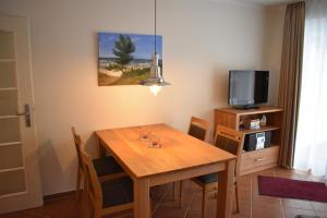a dining room with a wooden table and a tv at Am Kurpark " Nr 812" in Baabe