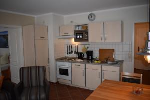 a kitchen with white cabinets and a sink and a table at Am Kurpark " Nr 812" in Baabe