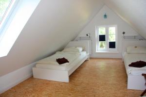 a attic room with two beds and a window at Kleiner Feldblick in Hinrichsdorf