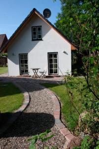 una casa blanca con una mesa de picnic delante de ella en Kleiner Feldblick en Hinrichsdorf