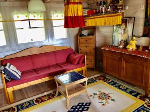 a living room with a red couch and a table at Himalayan cabin Inkoo in Inkoo