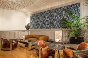 a living room with furniture and a large painting on the wall at Le Boutique Hotel & Spa in Bordeaux