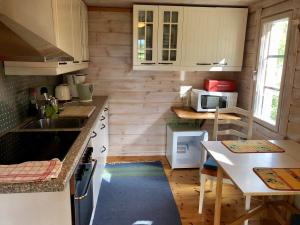 uma pequena cozinha com um lavatório e uma mesa em Himalayan cabin Inkoo em Inkoo