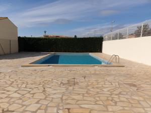 a swimming pool in a yard with a stone patio at horizon sur mer 1137 in Saint Pierre La Mer