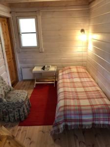 a room with a bed and a table and a window at Himalayan cabin Inkoo in Inkoo