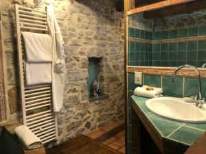 a bathroom with a sink and a stone wall at Restaurant et Chambres d'Hôtes La Ferme de Cornadel in Anduze +52 photos