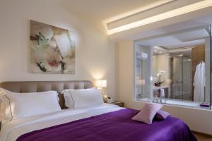 una camera da letto con un letto grande e uno specchio di O Monot Boutique Hotel Beirut a Beirut
