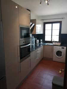 a kitchen with a stove and a microwave at Casa Castillo in Caleta De Fuste