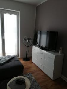 una sala de estar con TV de pantalla plana en un armario blanco en Storchennest, en Raduhn