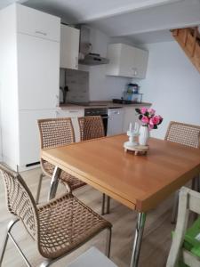 cocina con mesa de madera y sillas en Storchennest en Raduhn