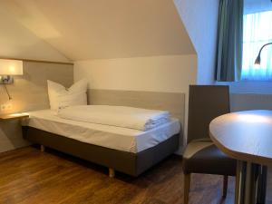 a small room with a bed and a table and a table at Hotel Waibstadter Hof in Waibstadt