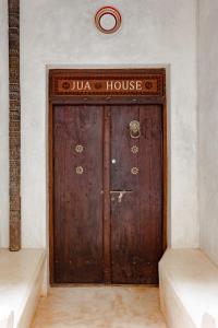 
a door leading to a room with a clock on the wall at Jua House in Lamu
