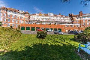 a large building with cars parked in a parking lot at Holiday Beach Flat in Bournemouth, England, UK in Bournemouth