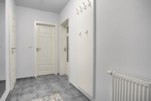a hallway with white walls and a door and tile floor at Villa Obendtied, FW 3 in Zingst