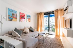 uma sala de estar com um sofá e uma grande janela em La Francesa Triana em Sevilha