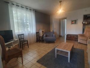 een woonkamer met een tv en een tafel en stoelen bij Appartement les abeillons in Vinon-sur-Verdon