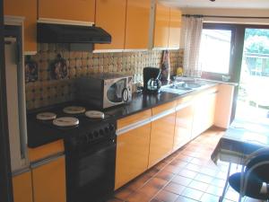 a kitchen with a black stove and a microwave at Frauke Bruhn in Fockbek