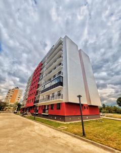 ein großes rotweißes Gebäude auf einer Straße in der Unterkunft Mall Luxury VI Apartment in Bacău