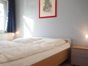 1 cama en un dormitorio con una foto en la pared en FeWo "Stems - W5", en Prerow
