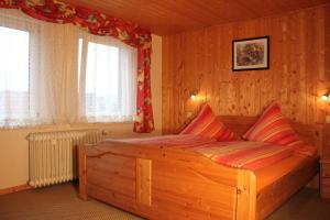 ブラウンラーゲにあるFerienwohnung Leonieのベッドルーム1室(木製ベッド1台、窓2つ付)