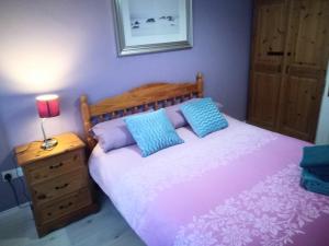 a bedroom with a bed with blue pillows and a lamp at Atlantic Point Stunning Sea View in Bundoran