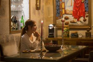 ウチヒサールにあるアンシア ホテルの蝋燭二脚のテーブルに座る女