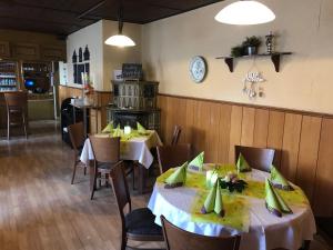 jadalnia z dwoma stołami i krzesłami w restauracji w obiekcie Landgasthof Deinert w mieście Parchen