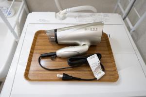 a hair dryer on a wooden tray on a table at stay's ジローズ浄心 601号 名古屋 民泊 駅近 in Nagoya