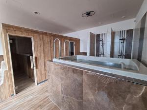 uma cozinha com um grande lavatório e armários de madeira em Penzión SESSLER *** em Trnava