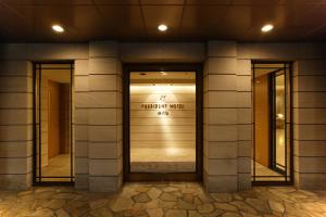a building with a door with a sign on it at President Hotel Mito in Mito