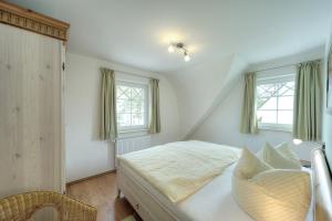a bedroom with a bed and two windows at Villa Sola Bona, FW 6 in Zingst